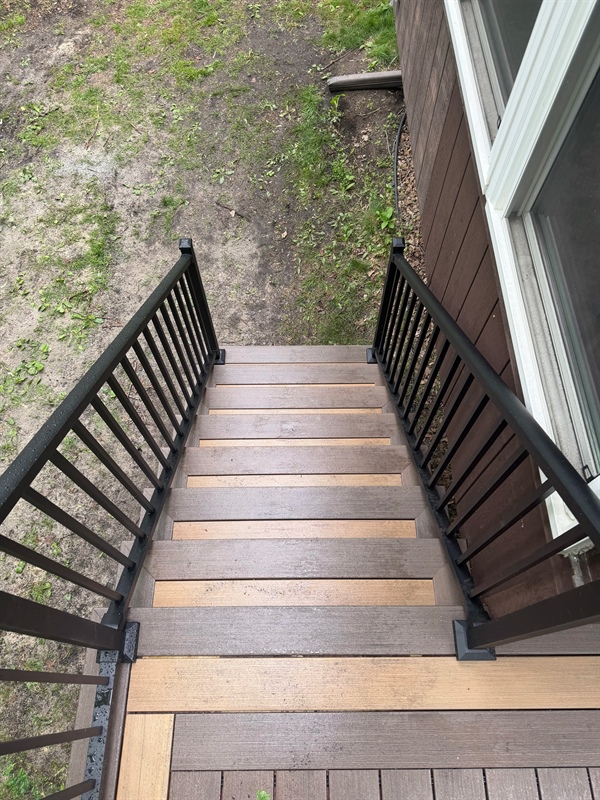 Composite deck stairs with black metal railings at a residential property in Ramsey, MN
