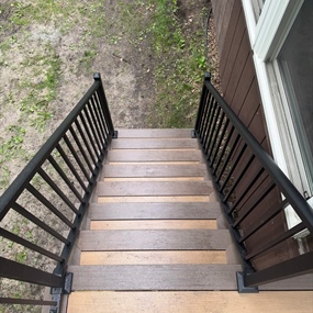 Composite deck stairs with black metal railings at a residential property in Ramsey, MN