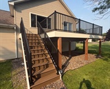 Completed composite deck replacement with stairs and black aluminum railings at a Brooklyn Park, MN home